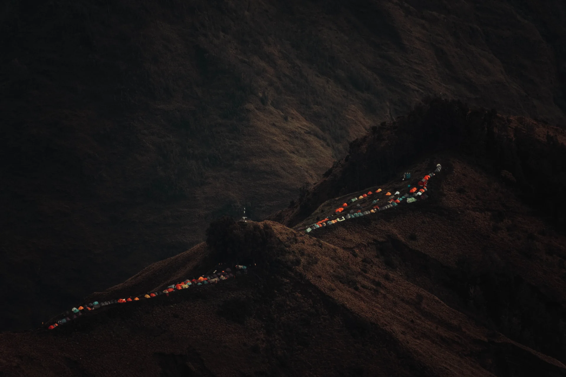 Colorful tents across a dark ridge